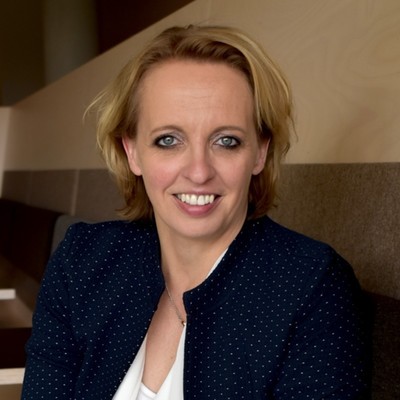 Natasja Verkooijen. Het is een portretfoto van Natasja. Zij draagt een zwart colbertje en glimlacht.